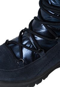 Stivali blu navy realizzati in una combinazione di camoscio e materiale sintetico lucido, con lacci neri e occhielli in metallo per una chiusura sicura.