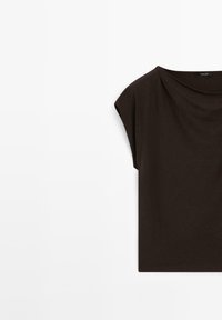 Haut marron à manches courtes avec un col drapé et loose, d'une texture douce, présentant un design minimaliste et sans embellissements visibles.