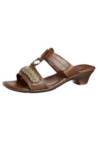 Sandales ouvertes en cuir marron avec un accent tressé vert et des éléments en métal circulaire, dotées d'un petit talon et de détails cousus.