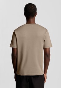 Beige T-Shirt mit kurzen Ärmeln aus weicher Baumwolle, ausgestattet mit einem klassischen Rundhalsausschnitt, geradem Saum und einer glatten Textur.
