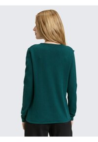 Türkisfarbener Pullover mit langen Ärmeln und rundem Halsausschnitt. Hergestellt aus weichem Stoff, mit glatter Textur und minimalistischem Design.