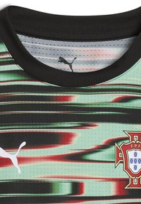 Zöld és fekete sportmez vízszintes csíkokkal, fekete gallérral, Puma logóval és egy színes Portugália nemzeti csapatának emblémájával.