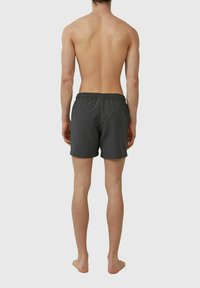 Graue Badeshorts mit elastischem Bund, aus leichtem Stoff, von hinten betrachtet. Verfügt über ein einfaches Design und keine Muster.