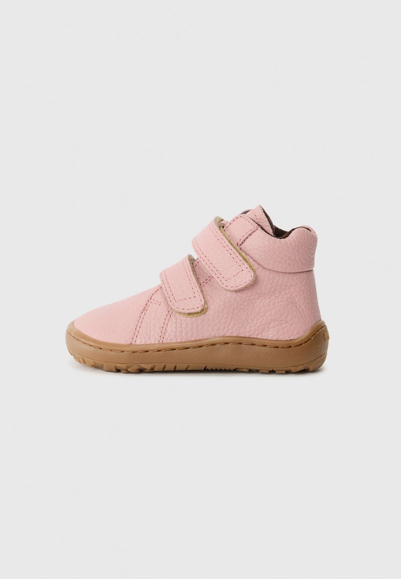 Zapatillas para niños pequeñas en color rosa, con parte superior de piel texturizada, dos tiras de velcro y suela de goma beige. Diseño simple con puntera redondeada.