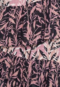 Tejido con capas que presenta un patrón de hojas en rosa y negro, con ramas delgadas y hojas alargadas sobre un fondo de material texturizado.
