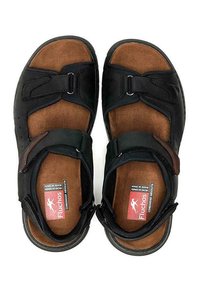 Las sandalias negras de punta abierta presentan una combinación de materiales de cuero y ante, correas ajustables y una plantilla acolchada marrón con marca.
