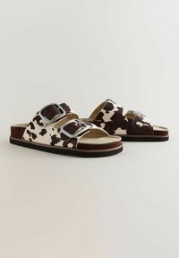 Sandaler i kosskinnsmönster med två justerbara silverfärgad spännen, en mjuk mocka ovandel, bruna accenter och en texturerad sula.