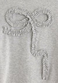 Grå tekstil med et loopet, rynket kantdesign. Texturen er blød med subtile variationer i stoffets overflade.