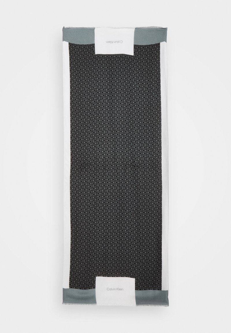 Écharpe Calvin Klein en noir et blanc avec un motif "CK" répété et des sections de bordure grises aux extrémités courtes.