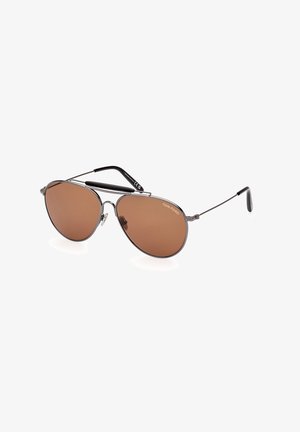 Aviator-style sunglasses with brown lenses, metal frame, and thin arms. Features silver accents and a black temple tip. Brand: Tom Ford.