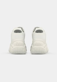 Adidași albi cu un exterior sintetic neted, design rotunjit, talpă groasă cu amortizare și accente cu logo gri pe călcâie.