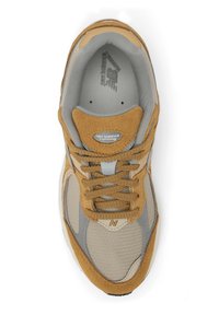 Scarpa da corsa beige e grigia con corpo in rete, dettagli in suede e lacci rotondi. Presenta un collare imbottito e un logo sulla linguetta.