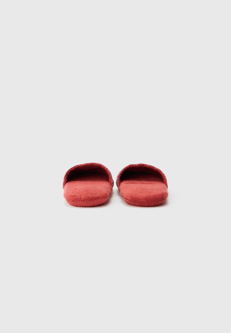 Red fabric slippers with a soft texture, open-toe design, and flat soles, featuring a simple, minimalist shape without additional accents.