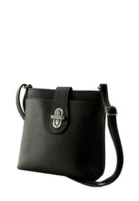 Schwarze Lederhandtasche mit strukturierter Oberfläche, einem Druckknopfverschluss und einem einzelnen verstellbaren Trageriemen. Verfügt über silberfarbene Beschläge und Nähedetails.