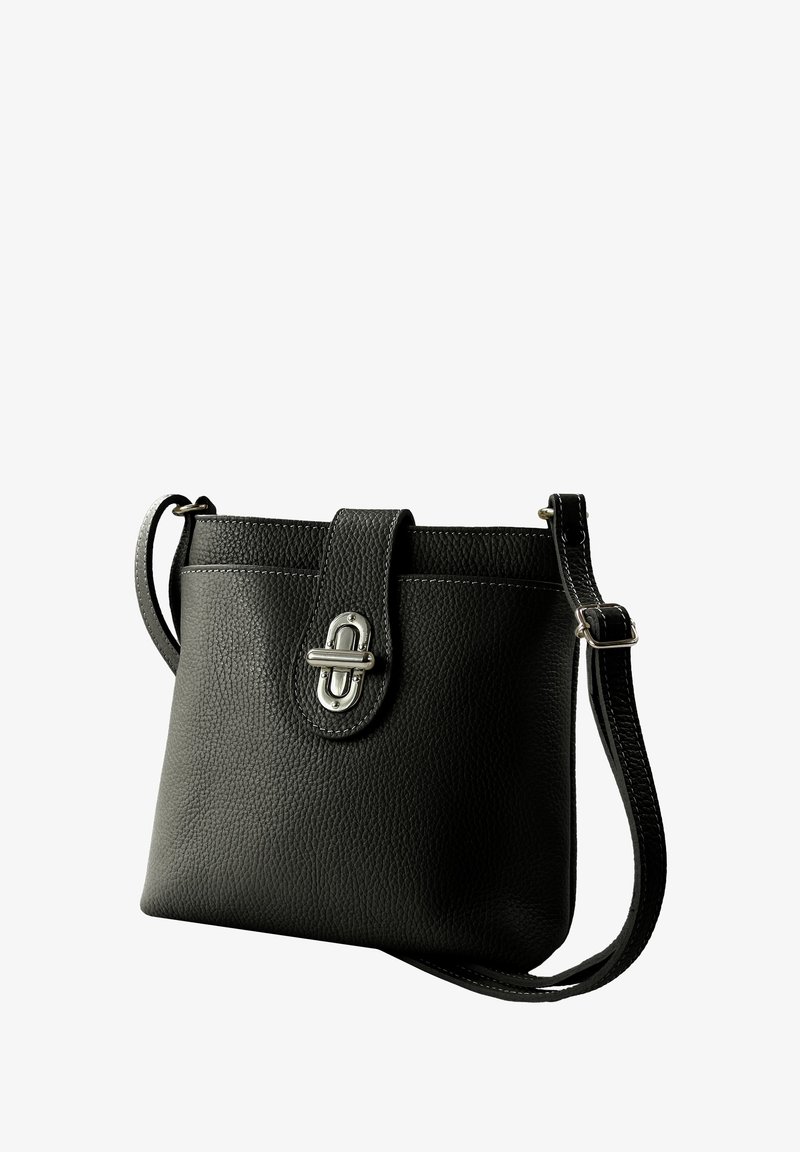 Schwarze Lederhandtasche mit strukturierter Oberfläche, einem Druckknopfverschluss und einem einzelnen verstellbaren Trageriemen. Verfügt über silberfarbene Beschläge und Nähedetails.