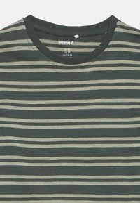 Zelené a béžové pruhované tričko vyrobené z mäkkej bavlny. Má okrúhly výstrih a krátke rukávy s pohodlným strihom.