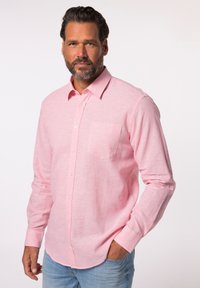 Camicia a maniche lunghe color rosa chiaro con bottoni, realizzata in un tessuto testurizzato. Presenta una tasca a toppa e un logo discreto sul lato sinistro del petto.