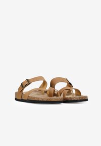 Sandali in pelle marrone con più cinturini e fibbie regolabili. Suola in sughero e gomma nera. Design con punta e tallone aperti.