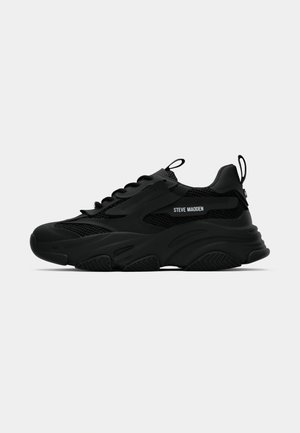 Black Steve Madden chunky sneaker with mesh panels, thick sole, pull tabs on tongue and heel, side logo lettering, shown in profile.