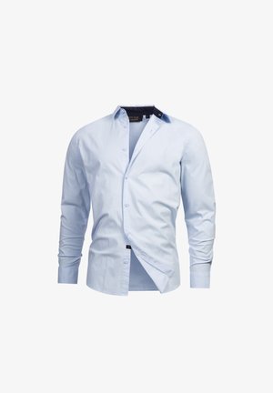 Lyseblå langermet skjorte med knapper laget av bomullsstoff. Har en klassisk krage, knappelukking foran og et distinkt marineblått preg på kragen.