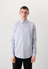 Lyseblå stripete skjorte med knapper og spiss krage, lange ermer og hvite knapper. Glatt stoff med en subtil glans.