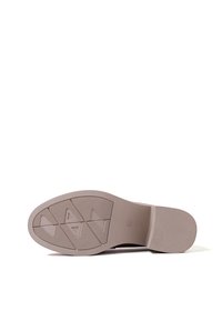 Suola di una scarpa, colore beige chiaro, materiale gommoso, superficie testurizzata con motivi geometrici e design antiscivolo, tacco piatto.