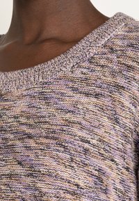 Pull en tricot avec un col large, motif texturé dans des teintes de violet, beige et noir, avec un col côtelé et un tissu doux.