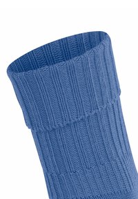 Cavigliera a coste, di colore azzurro chiaro, che mostra una superficie morbida e un bordo leggermente arrotolato, messa in risalto su uno sfondo bianco.