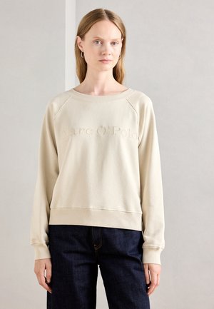 Sweatshirt beige avec col rond et poignets côtelés. Logo "Marc O'Polo" brodé sur le devant. Tissu doux et lisse, coupe décontractée.