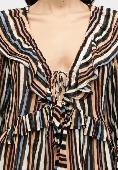 Ριγέ πολύχρωμο μπλουζάκι με βολάν στα άκρα, βαθύ V-λαιμόκοψη και ζώνη στη μέση. Το υλικό φαίνεται ελαφρύ με υφή.