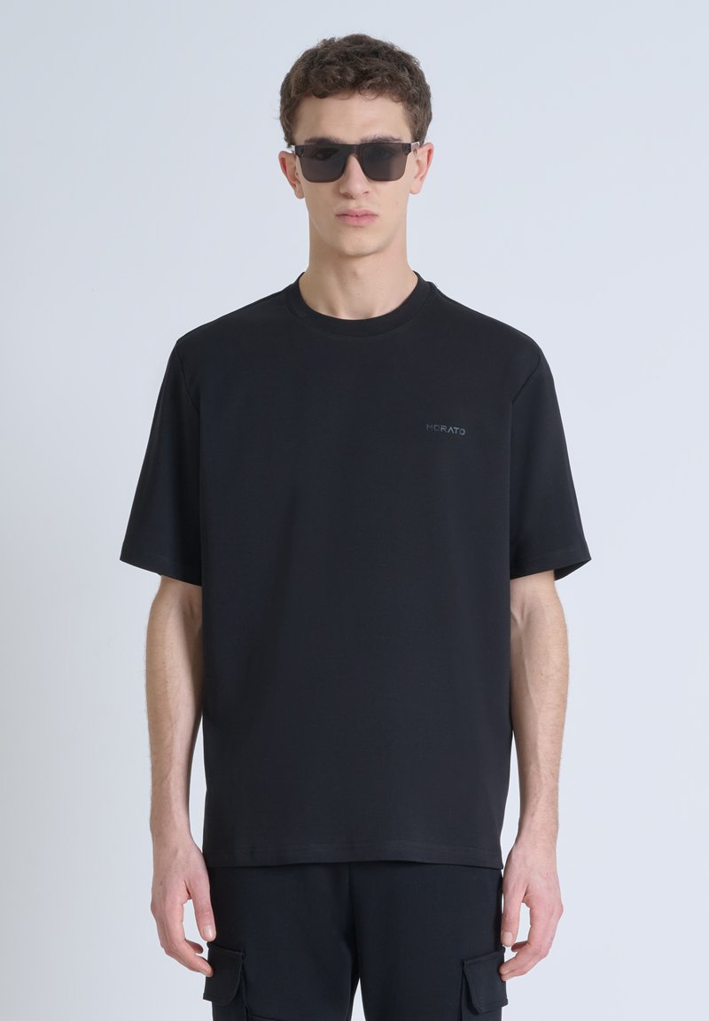 T-shirt nera a maniche corte con scollo rotondo, con un piccolo logo grigio sul lato sinistro del petto, realizzata in un tessuto liscio e traspirante.