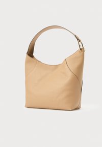 Beżowa skórzana torba na ramię o zakrzywionym, teksturowanym korpusie. Posiada szeroki pasek i subtelne detale szwów, z akcentami w złotym odcieniu metalu.