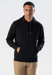 Sort hættetrøje med pullover-design, justerbare snore og forlommer. Har en blød tekstur og ribbede manchetter, parret med kaki bukser.