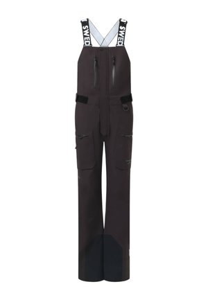Combinaison noire imperméable avec bretelles réglables portant l'étiquette Suède, poches zippées sur la poitrine et les cuisses, et zones renforcées aux genoux et aux chevilles.
