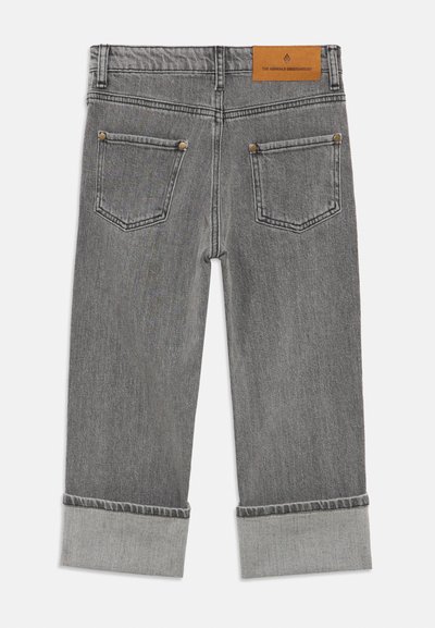 Pelēki džinsa džinsi ar taisnu griezumu, ar atloku apakšmalām un divām aizmugures kabatām. Jostasvietā ir brūnas ādas zīmola etiķete.