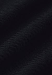 Czarna tkanina o prążkowanej fakturze, prezentująca miękkie zagięcia. Materiał wydaje się elastyczny i gładki, podkreślając głęboki, jednolity kolor.