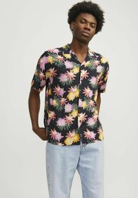 Camisa de manga corta hecha de tela ligera con un fondo negro y patrones de flores coloridos en rosa, amarillo y verde.