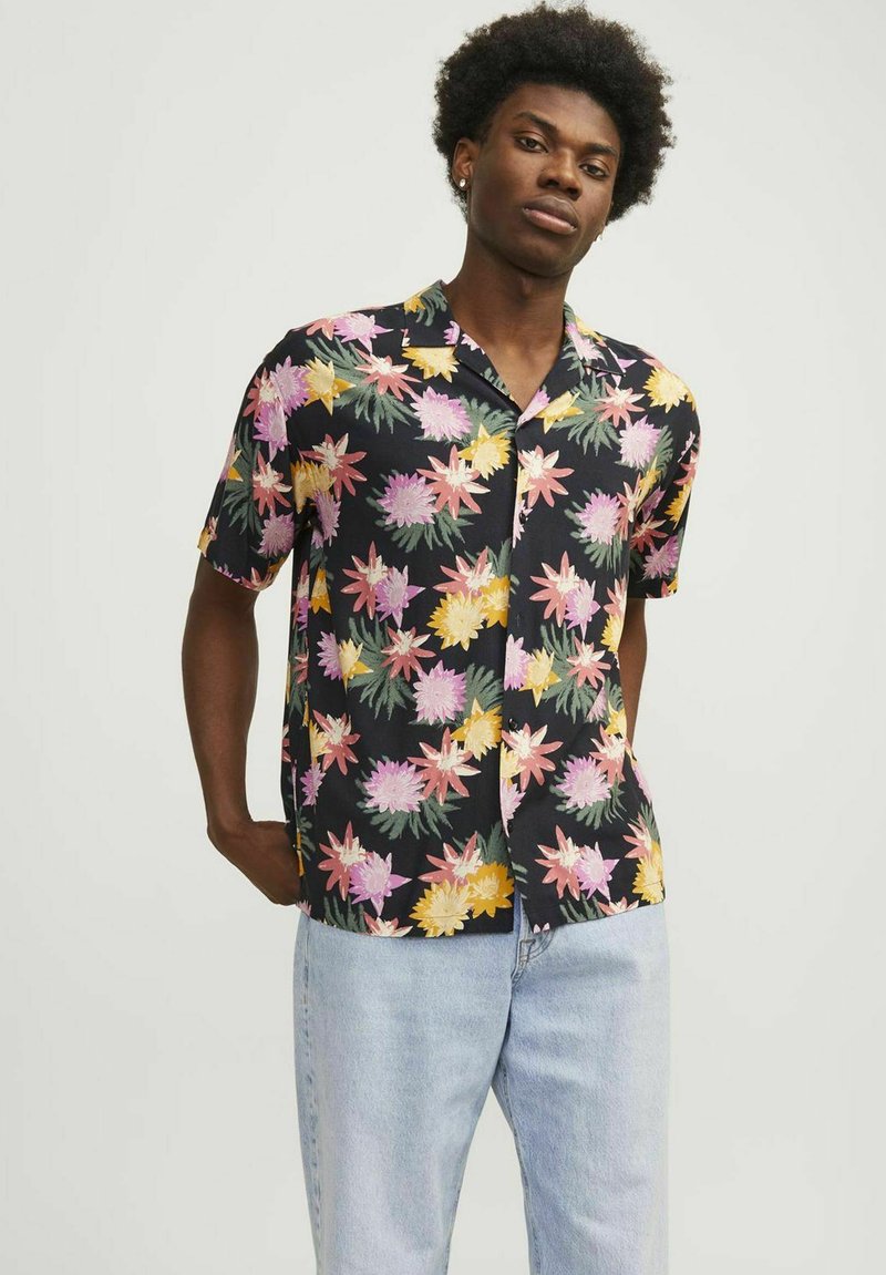 Camisa de manga corta hecha de tela ligera con un fondo negro y patrones de flores coloridos en rosa, amarillo y verde.