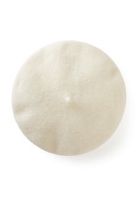 Zachte, ronde witte wollen baret met een kleine centrale knobbel, geïsoleerd op een witte achtergrond.