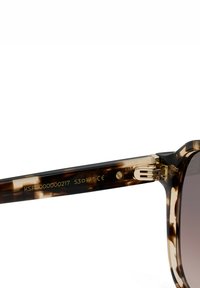 Sonnenbrillenbügel aus Schildpatt mit goldenem Scharnier sowie eingravierter Modellnummer, Größenangaben und CE-Zertifizierung.