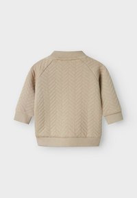 Giacca per neonati trapuntata beige con motivo a zigzag, maniche lunghe, colletto a coste, polsini e orlo, vista dal retro.