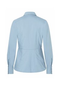 Camicia azzurra a maniche lunghe con colletto, vita aderente e polsini abbottonati. Tessuto liscio e silhouette su misura con dettaglio sull'inserto posteriore.