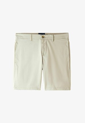 Ljusbeiga shorts gjorda av mjuk tyg. Har en framknappsstängning, bältesöggor och två sidofickor.