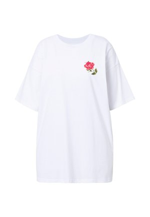 T-shirt oversize bianca in cotone, con una rosa rosa ricamata sulla parte sinistra del petto. Maniche corte e scollo rotondo.