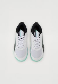Baskets de sport blanches avec des accents noirs et des détails en teal. Tige en maille, col rembourré et lacets plats. Design élégant avec un bout rond.