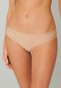 Beige seamless bikini underwear with a smooth texture and a low-rise fit. Features minimalistic design and solid color with no visible patterns.