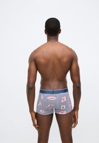 Csíkos, sötétkék boxeralsó piros és fehér logókkal. Rugalmas derékpánt, sima textúra, testhezálló kialakítás. Hátsó nézet.