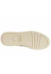 Weiße Gummi-Sohlen mit Fischgrätmuster, strukturiertem Oberflächenbelag und zentralem Logo, mit leichten Konturen für verbesserten Grip.