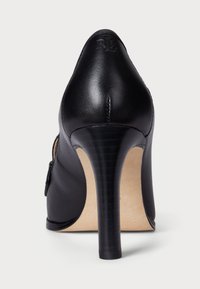 Črne usnjene visoke pete s koničastim nosom, eleganten silhuet in teksturirano peto. Ima embosirano "RL" logo na hrbtni strani.