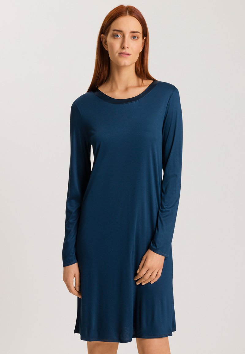 Vestido de manga larga en un profundo azul marino, confeccionado con una tela suave. Presenta un escote redondo y una silueta fluida, que llega justo por encima de las rodillas.